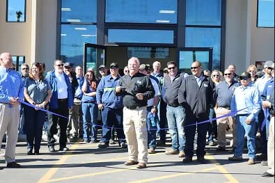 Group of people at ribbon-cutting ceremony outdoors