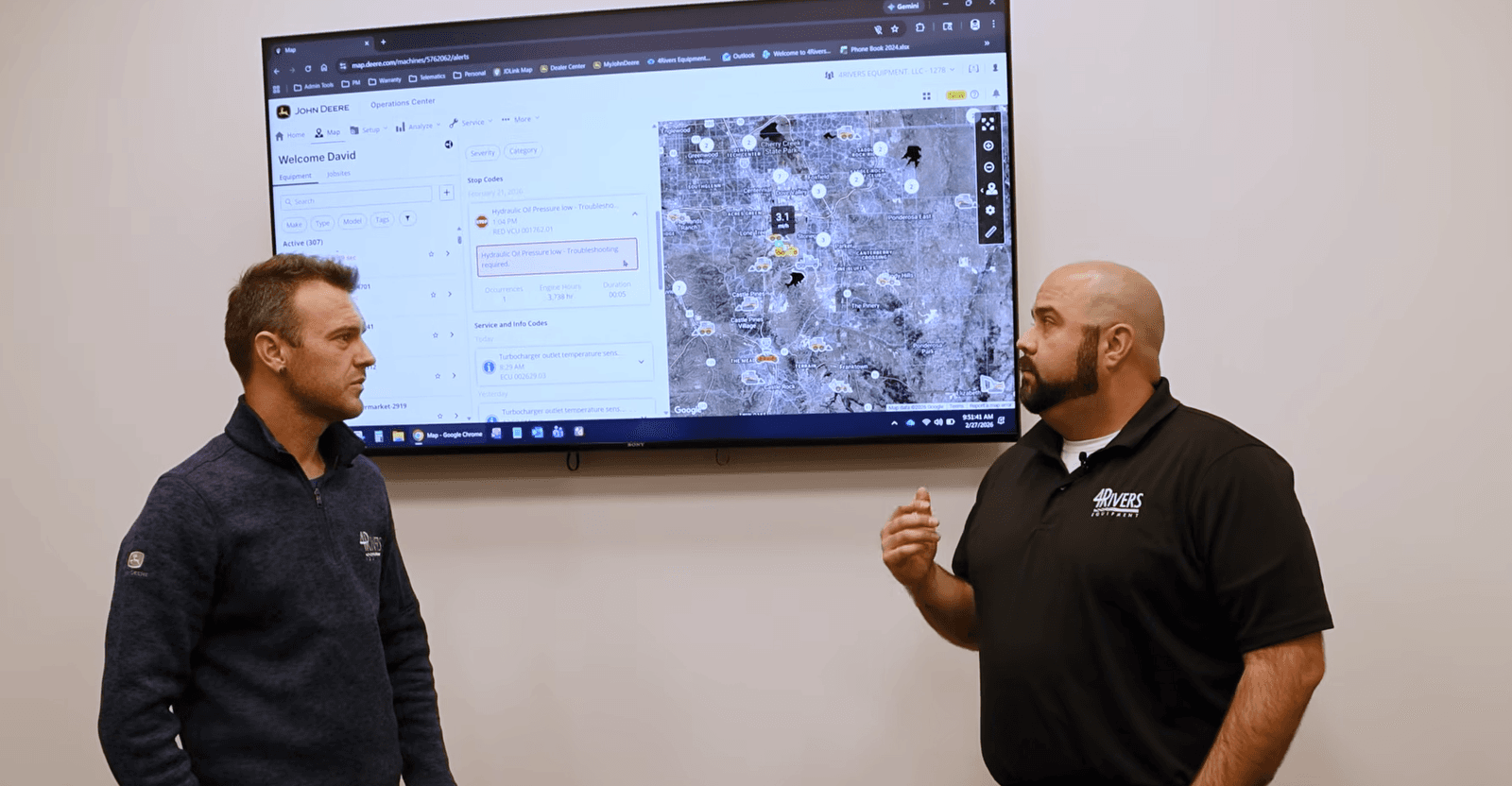 4RE | Davey and Josh from Foursight Solutions in front of a TV screen showing data.