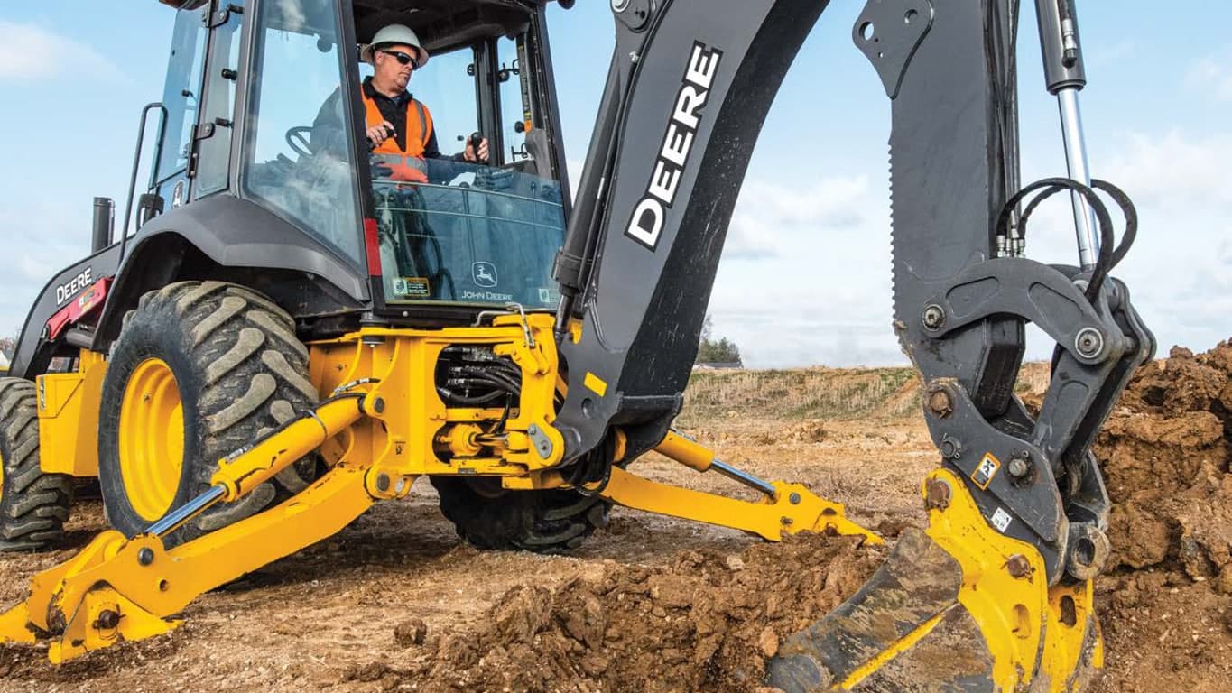 A close-up of an operator using the 310P-Tier Backhoe to scoop dirt. | 4re Equipment | ID: 310PBH