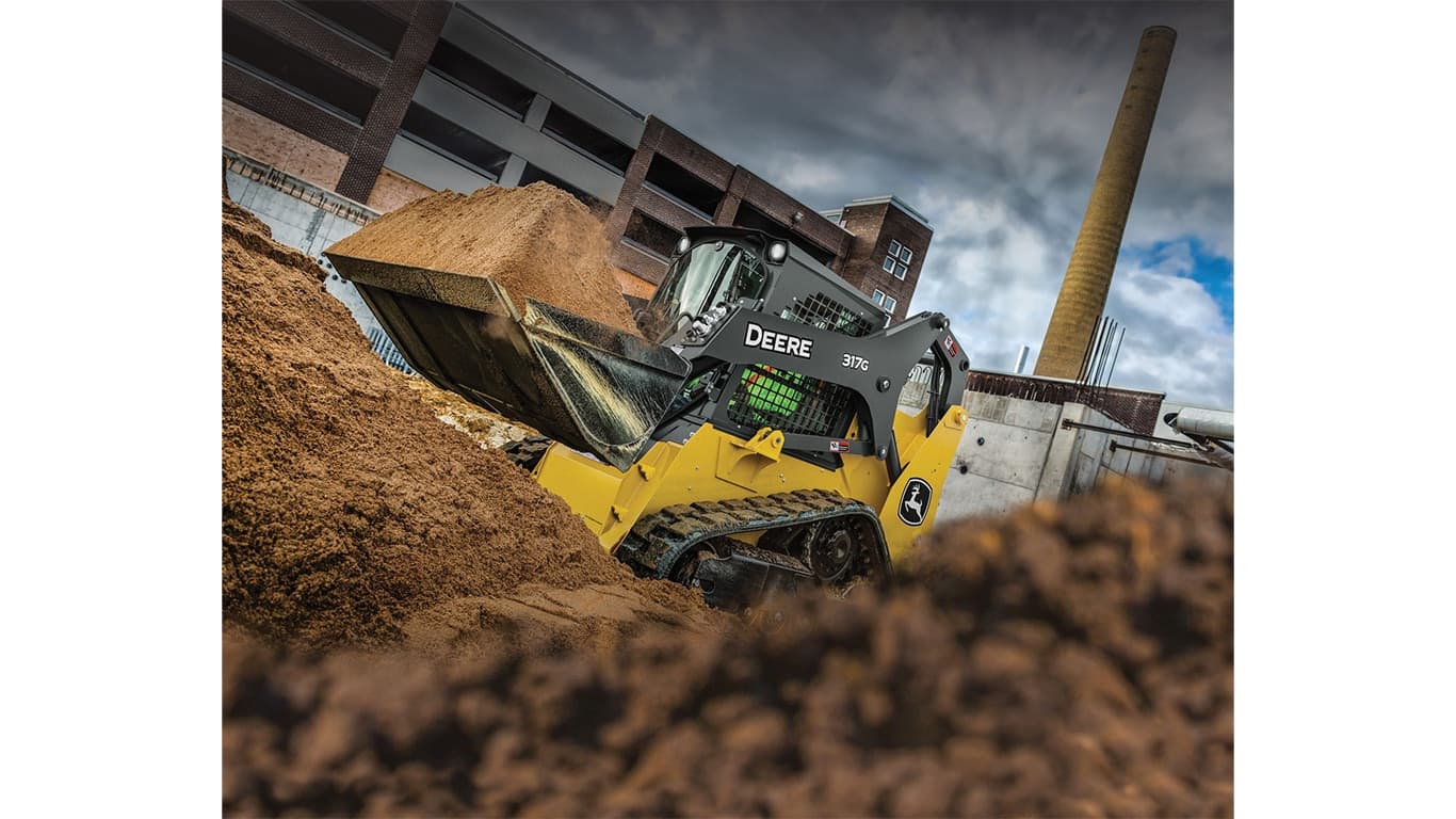 A 317G Compact Track Loader scooping dirt at a worksite. | 4re Equipment | ID: 317gft4