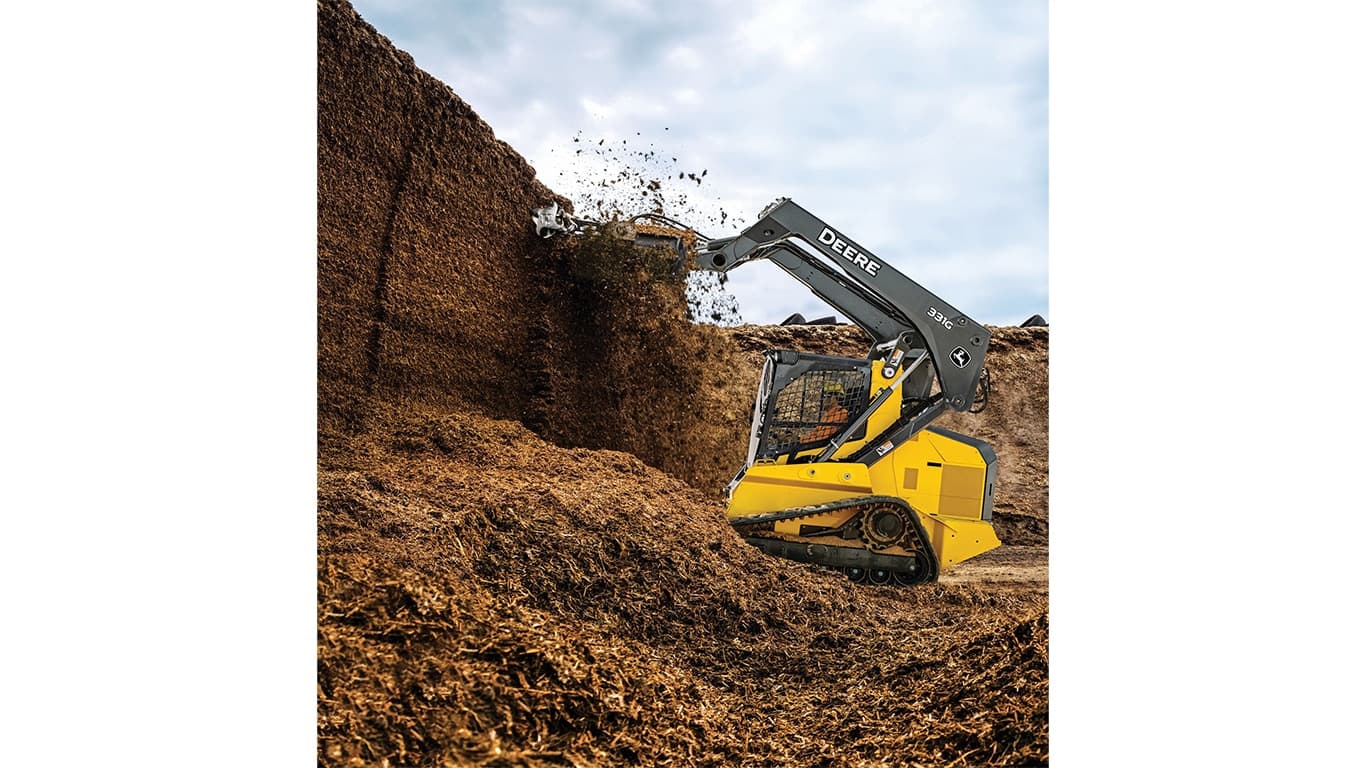 A 331G Compact Track Loader tearing down a wall of mulch and dirt with an AD7 silage defacer attachment. | 4re Equipment | ID: 331gxt