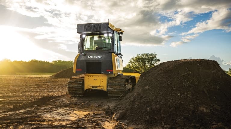 Rear view of a 450P Dozer next to a topsoil stockpile. | 4re Equipment