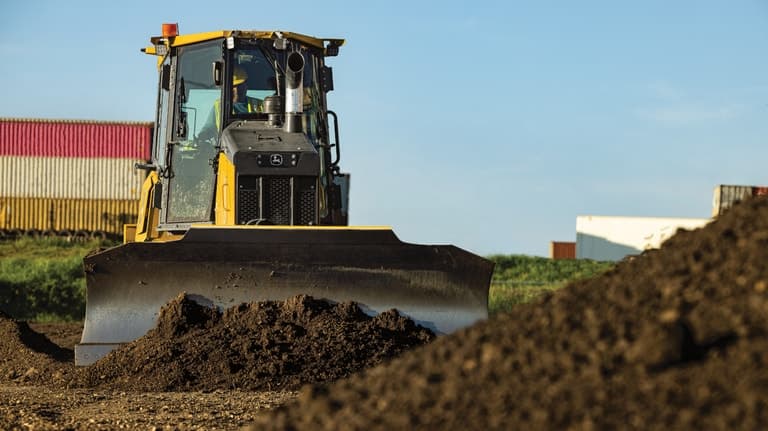 Front view of a 550P Dozer pushing dirt into a stockpile. | 4re Equipment