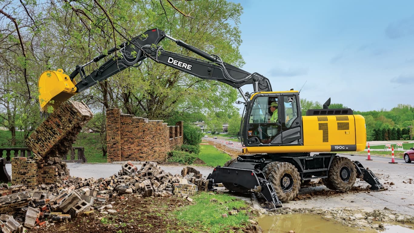 A 190GW Excavator being used to break down a brick wall in front of a road. | 4re Equipment | ID: 190gwff