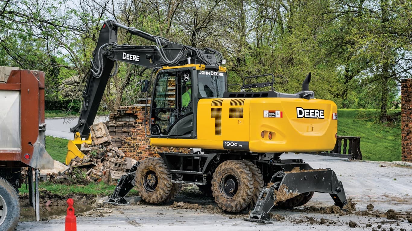 A 190GW Excavator scooping up brick from a demolished wall with an on-road truck to the left. | 4re Equipment | ID: 190gwff