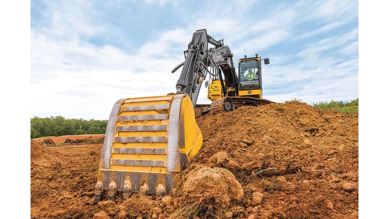 A close-up of the bucket on a 210P-Tier Excavator scooping dirt from a stockpile. | 4re Equipment