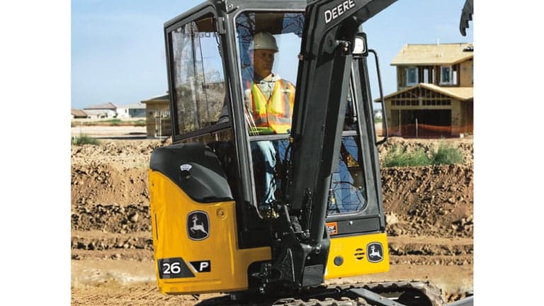 A close-up of an operator sitting in the cab of a 26P-Tier Excavator. | 4re Equipment
