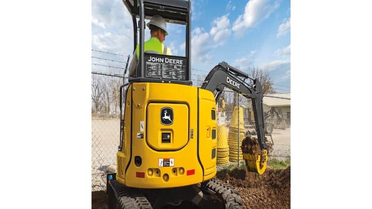 The backside of a 30P-Tier Excavator scooping dirt from a pile to the right of the machine. | 4re Equipment