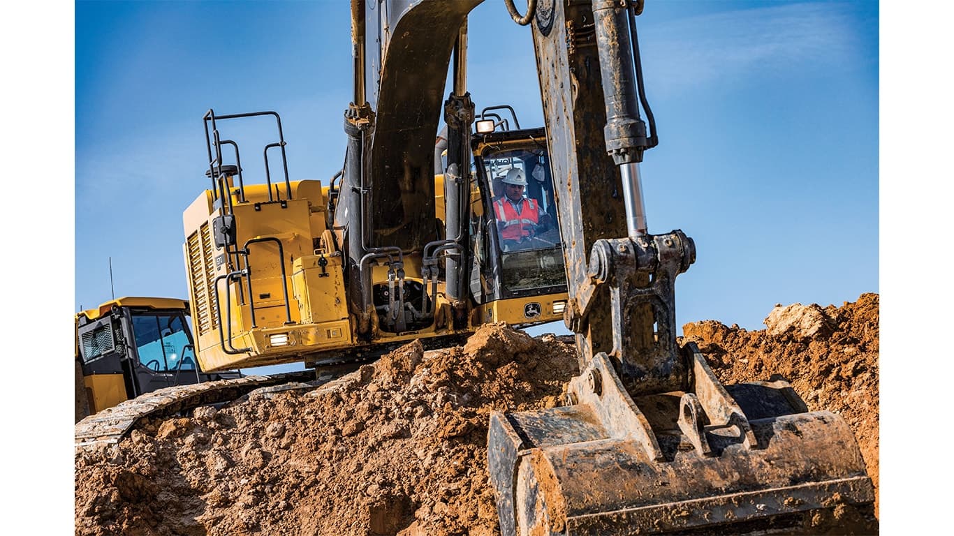 An operator using a 670P-Tier Excavator to scoop up dirt at a worksite. | 4re Equipment | ID: 670PEXFT4