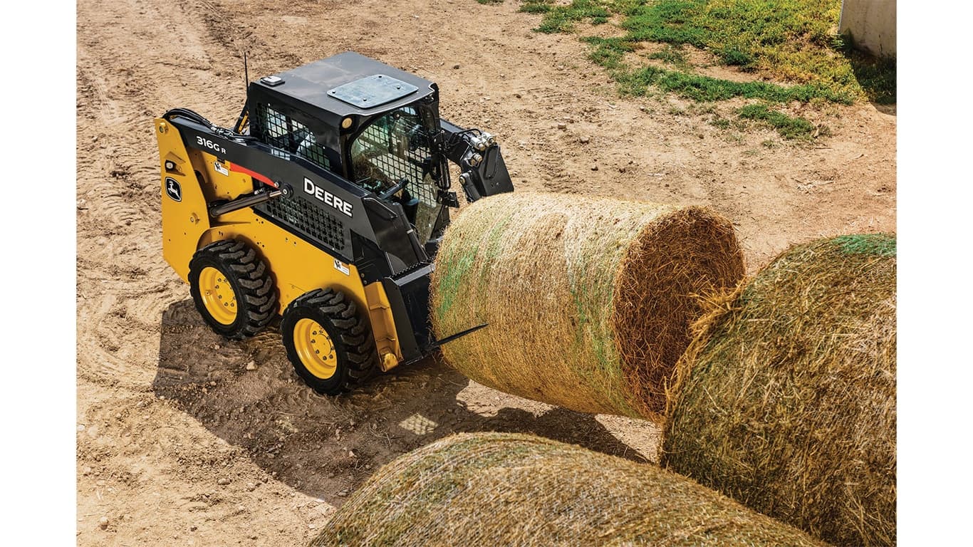 A 316G Skid Steer with bale spear attachment moving a hay bale. | 4re Equipment | ID: 316grft4