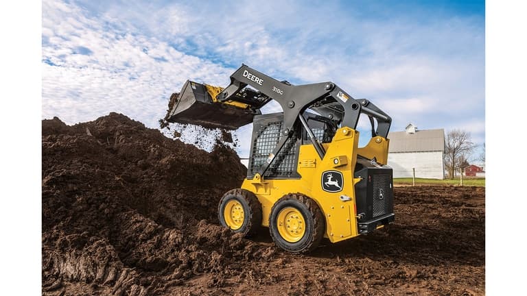 A 318G Skid Steer moves dirt at a worksite with a house in the background. | 4re Equipment