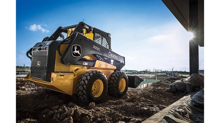 A 332G Skid Steer parked at the top of a worksite on a sunny day. | 4re Equipment